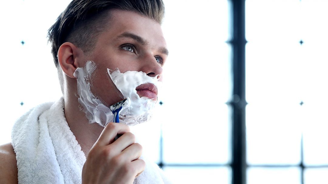 man shaving his beard scaled