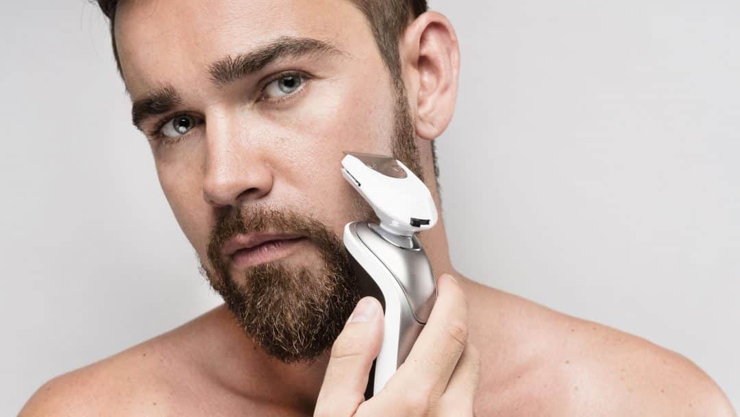 man using electric shaver scaled